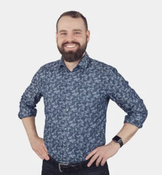 A Man With A Beard And Mustache Wearing A Blue Shirt